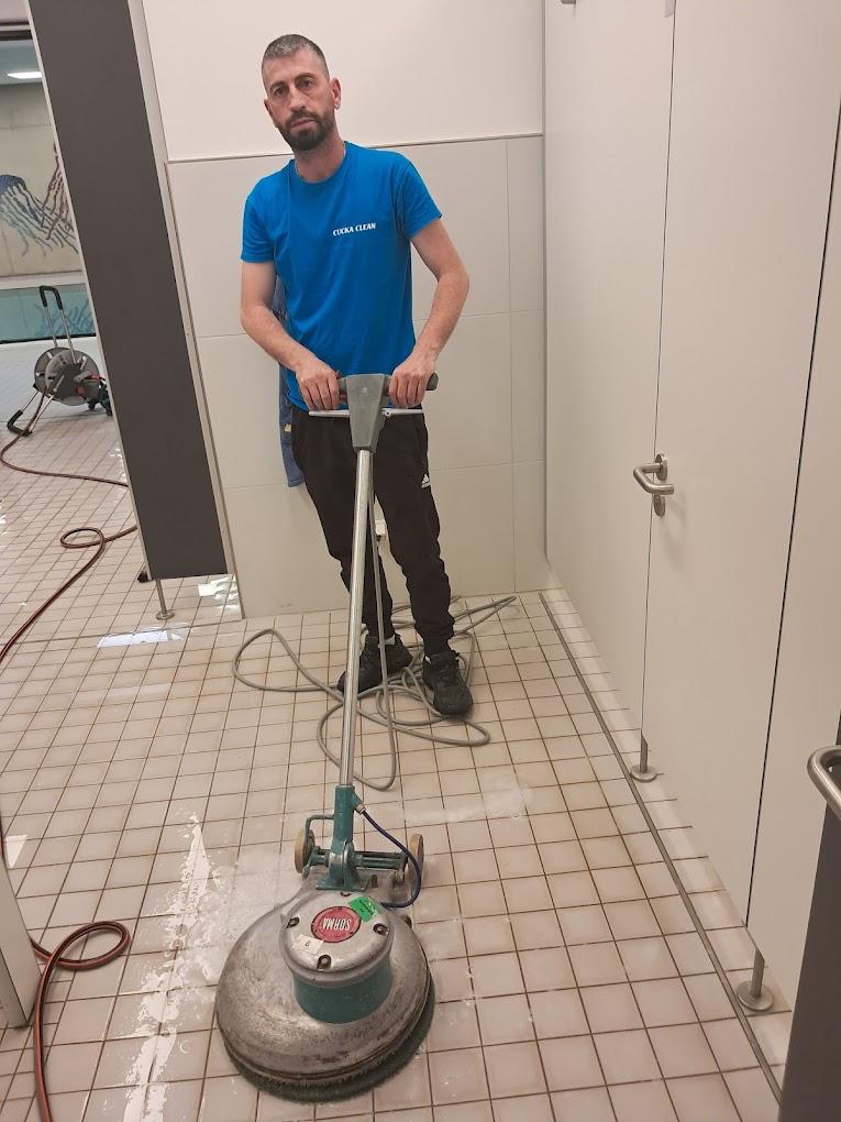 Beispielmotiv zur Gebäudereinigung Andernach: Reinigungskraft mit Bodenmaschine auf Fliesen